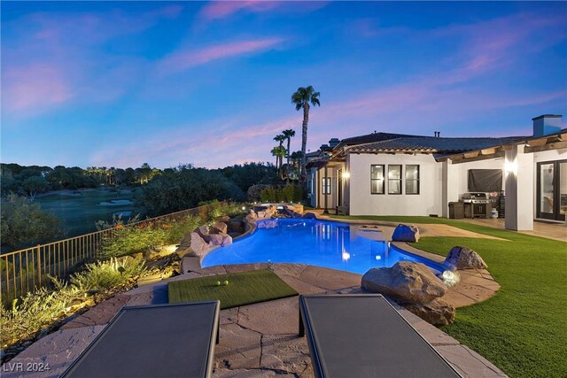 pool at dusk featuring a yard and a patio