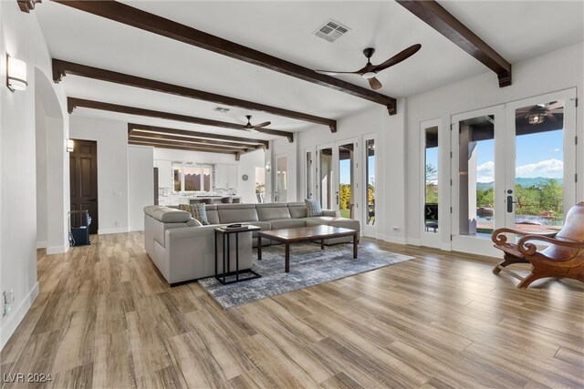 living room featuring ceiling fan, french doors, and light hardwood / wood-style flooring