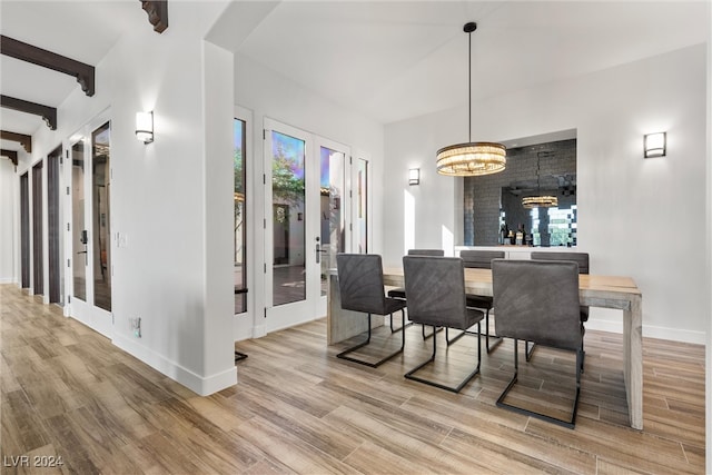 dining room featuring light hardwood / wood-style flooring, french doors, and beam ceiling