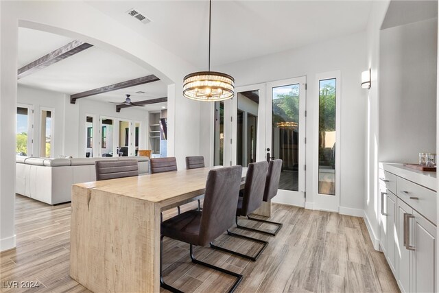 dining space featuring ceiling fan with notable chandelier, beam ceiling, french doors, and light wood-type flooring