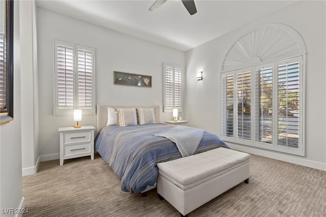 carpeted bedroom featuring ceiling fan and multiple windows