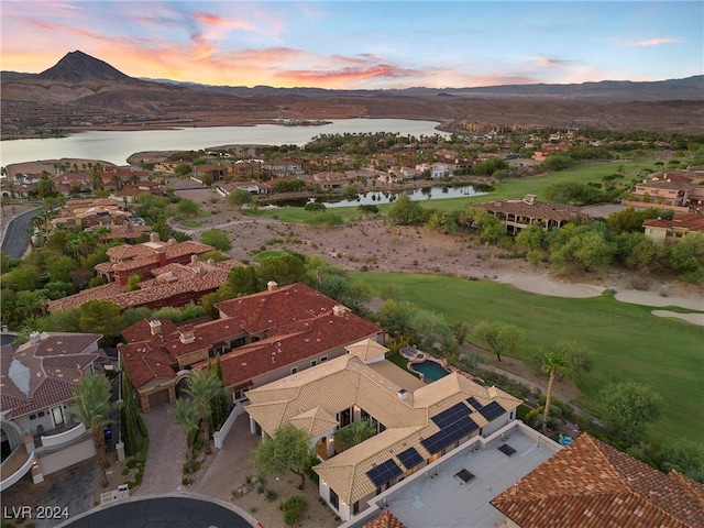 aerial view at dusk featuring a water and mountain view