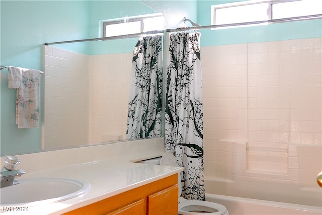 full bathroom with a wealth of natural light, shower / bath combo with shower curtain, vanity, and toilet