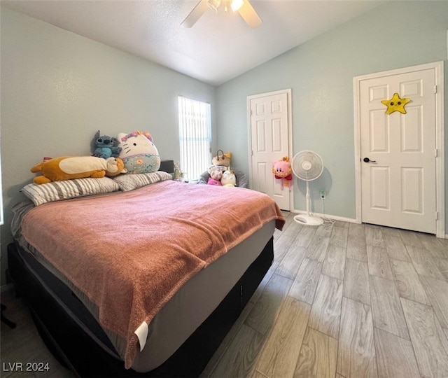 bedroom featuring ceiling fan, lofted ceiling, and light hardwood / wood-style floors