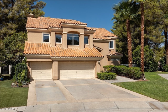 mediterranean / spanish house with a garage and a front lawn