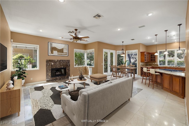 living room featuring ceiling fan, a fireplace, and a wealth of natural light