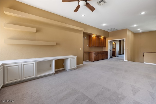 unfurnished living room with light colored carpet and ceiling fan