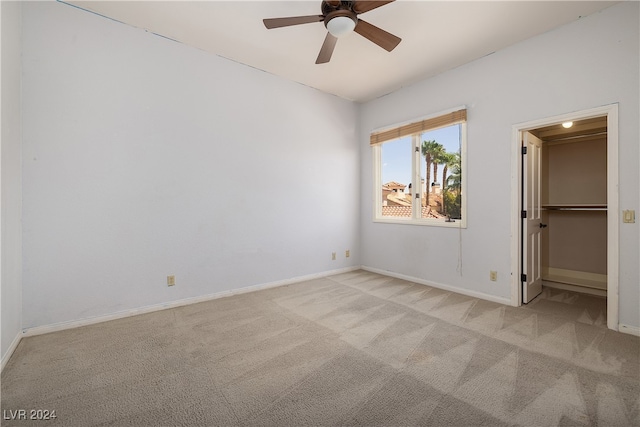 unfurnished bedroom with ceiling fan, light colored carpet, and a spacious closet