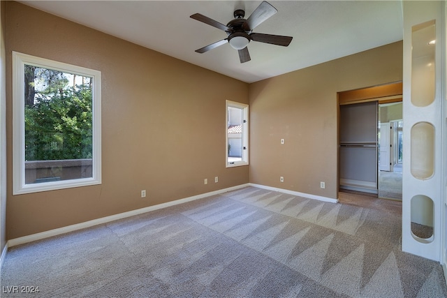 unfurnished bedroom featuring ceiling fan, a closet, and carpet