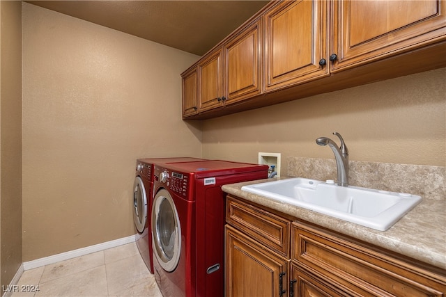 laundry room with cabinets, sink, light tile patterned floors, and washing machine and clothes dryer