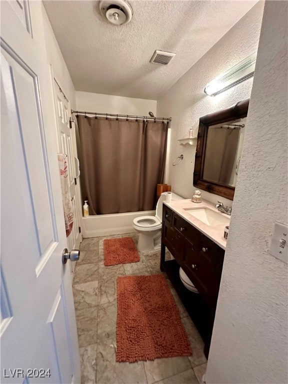 full bathroom with vanity, toilet, a textured ceiling, and shower / bath combo