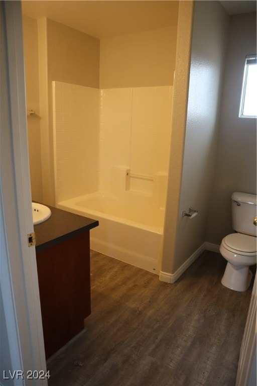 bathroom with toilet, hardwood / wood-style floors, and vanity