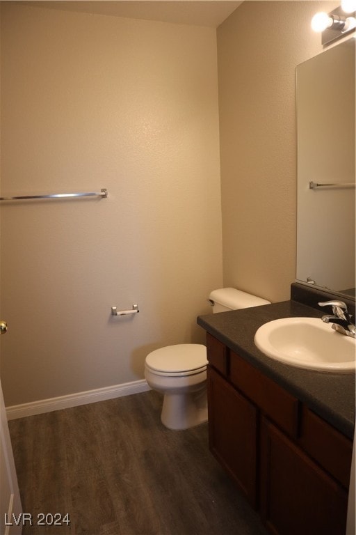 bathroom featuring vanity, hardwood / wood-style floors, and toilet