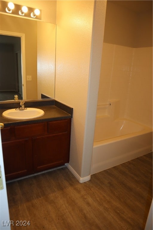 bathroom with hardwood / wood-style floors, vanity, and bathtub / shower combination