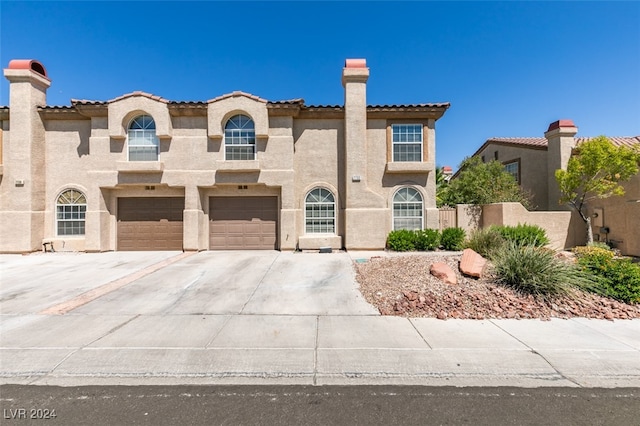 mediterranean / spanish-style home with a garage