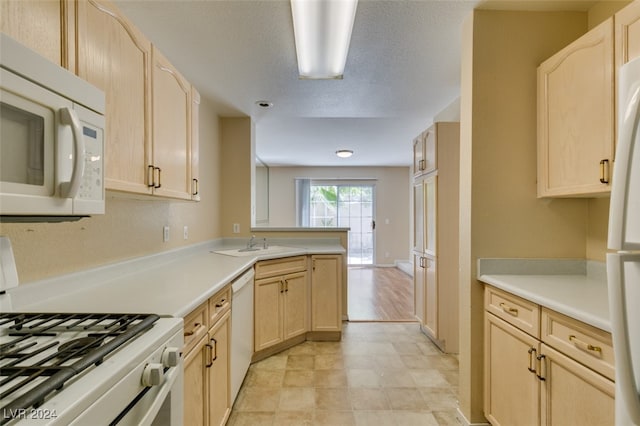 kitchen with white appliances, light tile patterned floors, and light brown cabinetry