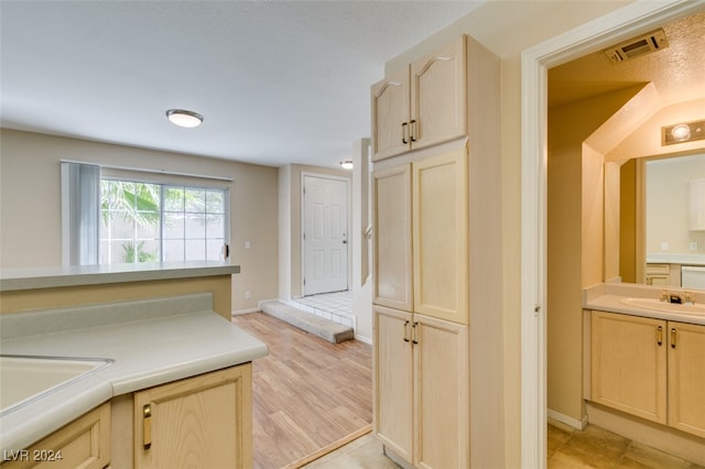 kitchen with light wood-type flooring, sink, and light brown cabinets