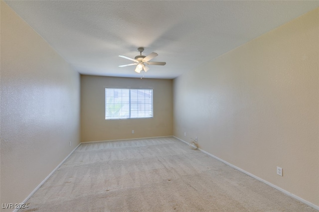 spare room featuring light carpet and ceiling fan