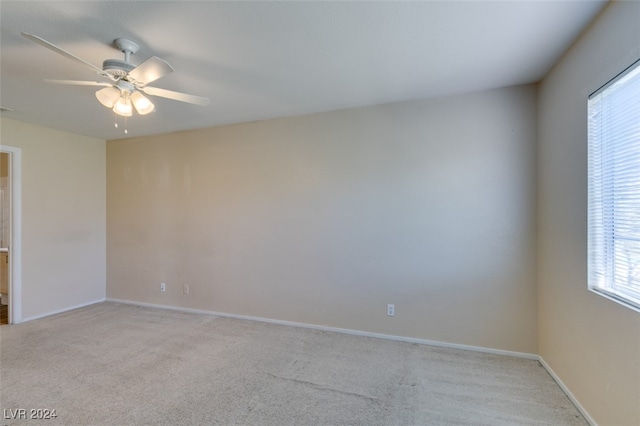 carpeted spare room featuring ceiling fan