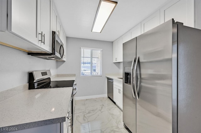 kitchen with stainless steel appliances, light tile patterned floors, white cabinetry, and light stone countertops