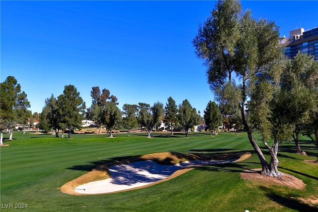 view of home's community with golf course view and a lawn