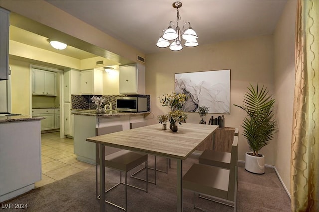 dining area with light tile patterned floors, visible vents, light carpet, and an inviting chandelier