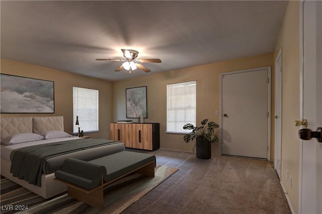 carpeted bedroom featuring ceiling fan, multiple windows, and baseboards