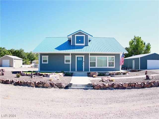 view of front facade featuring an outdoor structure, a porch, a garage, and metal roof