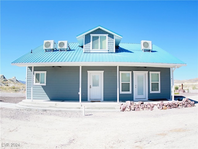 view of front of property featuring cooling unit, ac unit, covered porch, and a mountain view