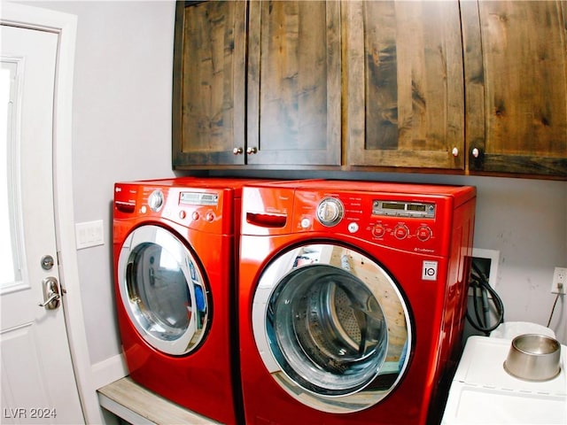 clothes washing area with cabinet space and washing machine and dryer