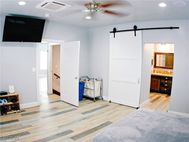 bedroom with wood finished floors, visible vents, baseboards, recessed lighting, and a barn door