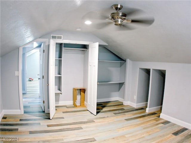 additional living space featuring a ceiling fan, baseboards, visible vents, lofted ceiling, and light wood-style flooring