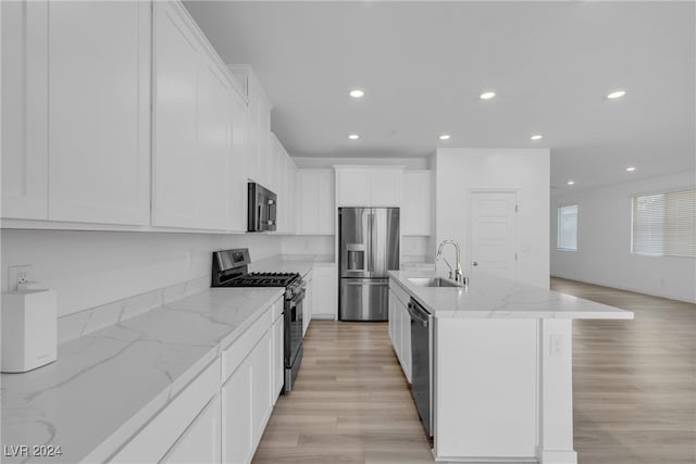 kitchen featuring an island with sink, stainless steel appliances, white cabinetry, and sink