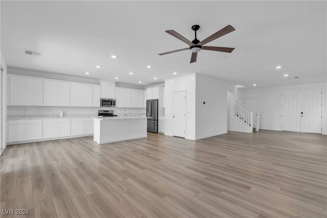 unfurnished living room featuring ceiling fan, light wood-type flooring, and sink