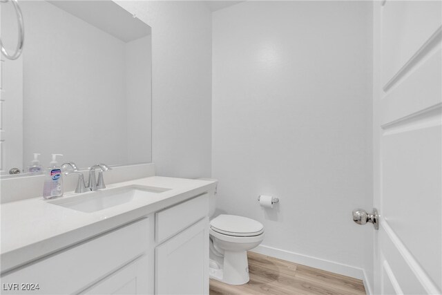 bathroom featuring vanity, hardwood / wood-style floors, and toilet