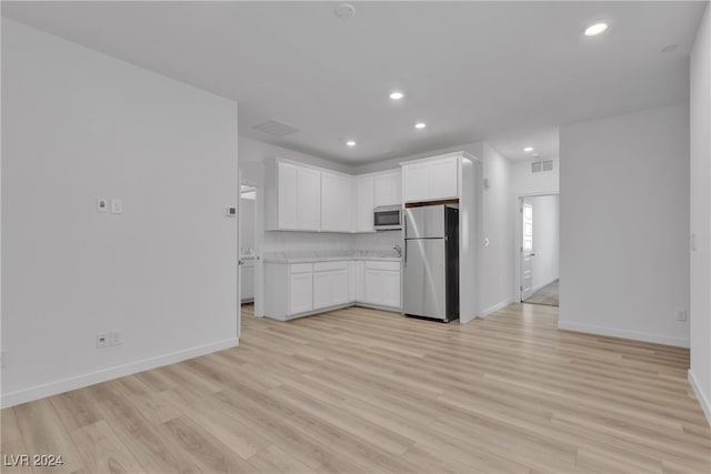 kitchen featuring white cabinets, stainless steel appliances, and light hardwood / wood-style floors