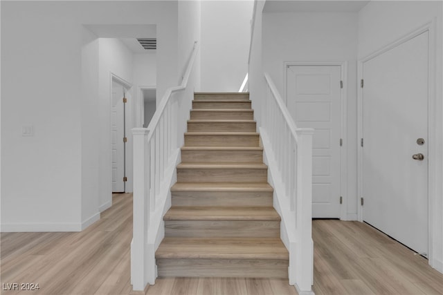 staircase with hardwood / wood-style flooring