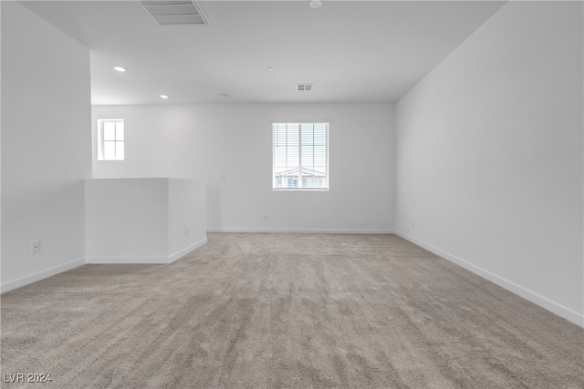 unfurnished room with a healthy amount of sunlight and light carpet