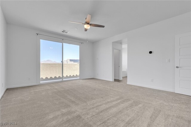 spare room featuring light carpet and ceiling fan