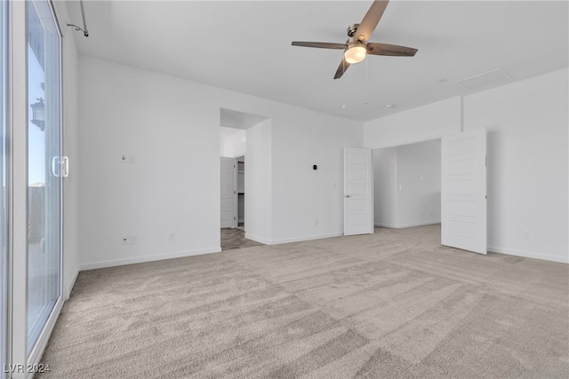 spare room with ceiling fan and light colored carpet