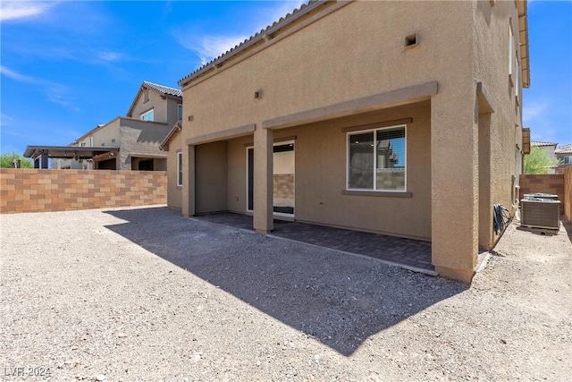 rear view of house featuring cooling unit and a patio area