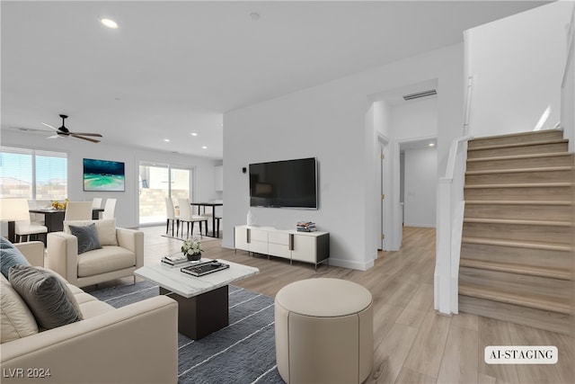 living room featuring wood-type flooring and ceiling fan