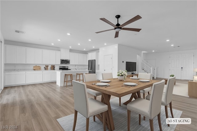 dining room featuring ceiling fan, light hardwood / wood-style flooring, and sink