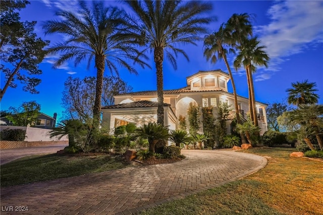 mediterranean / spanish house featuring a tile roof and stucco siding