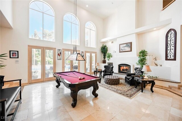 rec room with a towering ceiling, light tile patterned floors, pool table, and french doors