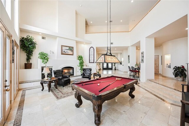 rec room with pool table, light tile patterned flooring, and a towering ceiling