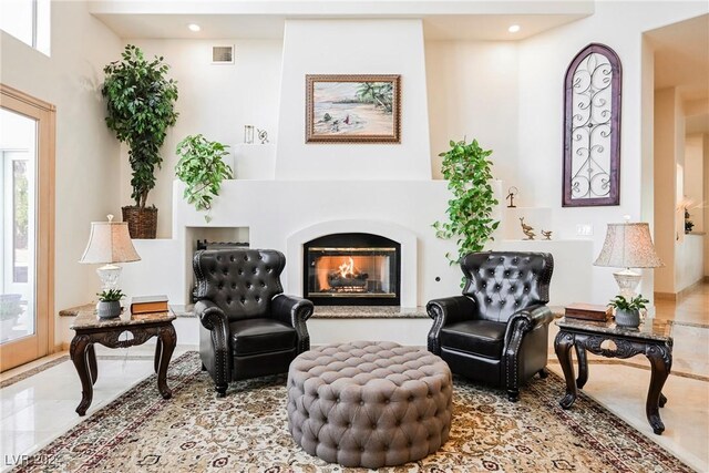 living area featuring a multi sided fireplace and tile patterned flooring