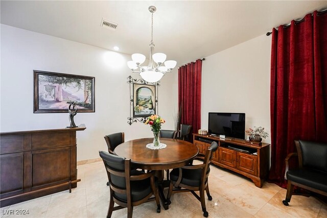 tiled dining area featuring a notable chandelier