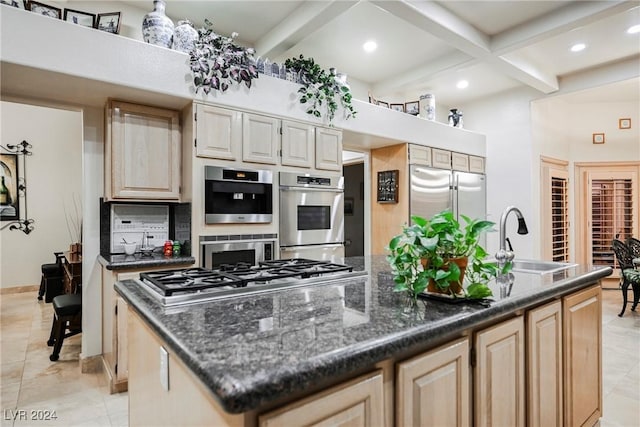 kitchen with stainless steel appliances, coffered ceiling, a sink, beam ceiling, and a center island