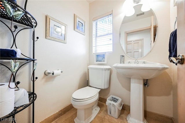 half bathroom with toilet, baseboards, visible vents, and tile patterned floors